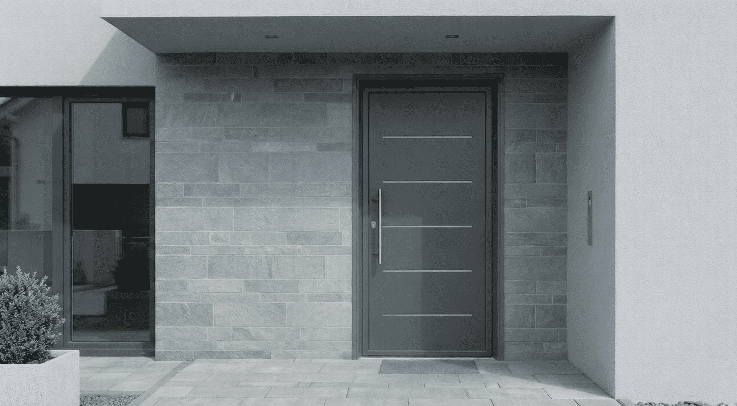 uerta blindada de aluminio de alta seguridad con herrajes reforzados y panel decorativo, instalada en una vivienda de Leganés para protección exterior contra robos.
