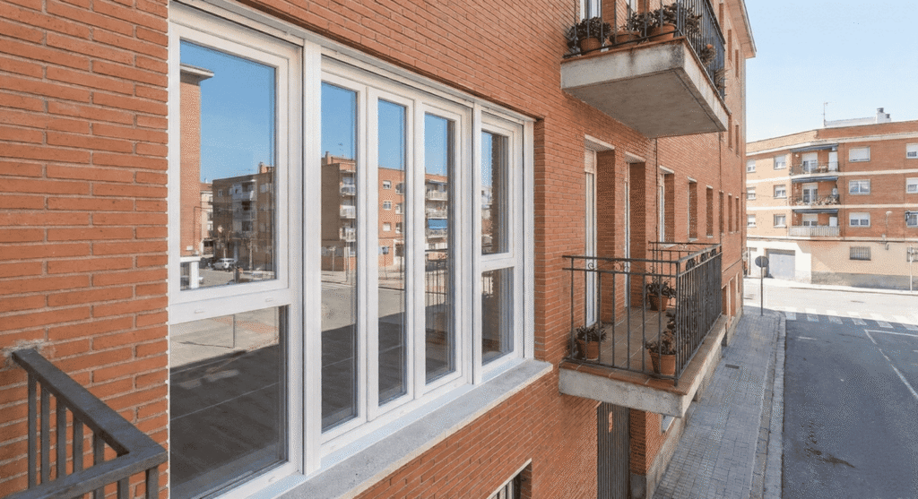 Instalación de ventana de PVC Kömmerling con perfil multicámara y herraje de seguridad en un piso de Leganés, optimizada para el máximo silencio y ahorro de energía.